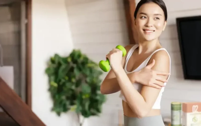 Eine junge Frau beim Sport mit einer kleinen Hantel in der Hand